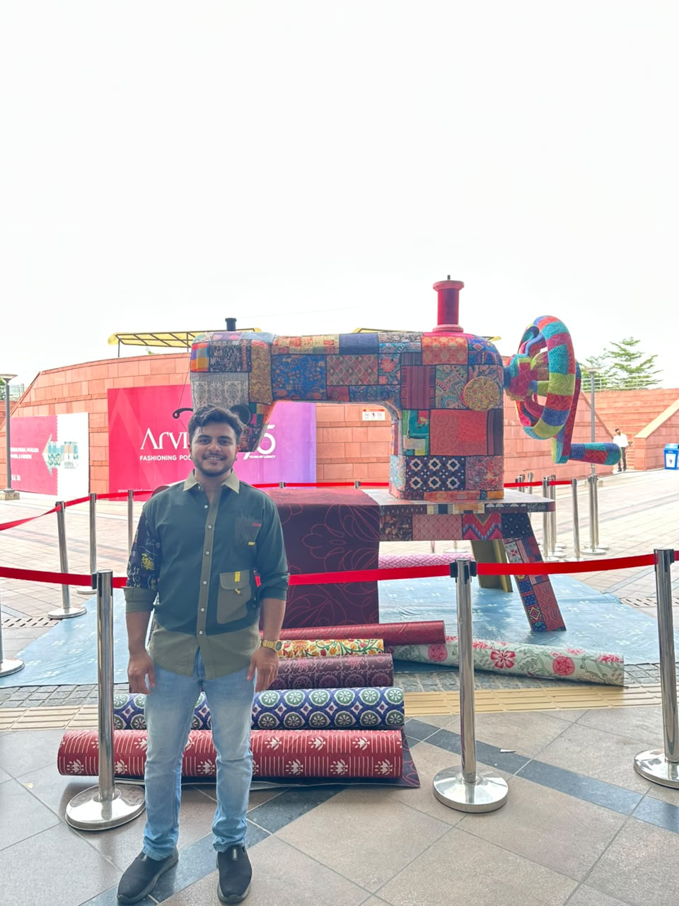 Vatsal Jain beside the patchwork sewing-machine installation at Bharat Tex 2026
